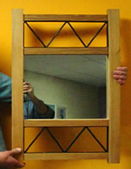 Student holding mirror in wooden frame