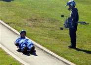 A student riding his luge down the track