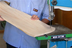 Student cutting a skateboard shape into the pressed wood