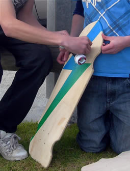 Student attaching wheels to a skateboard 