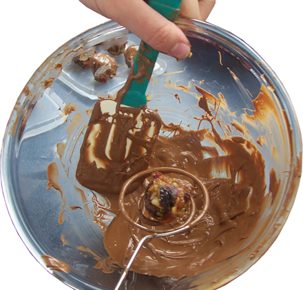 Nicky coating the mixture in chocolate