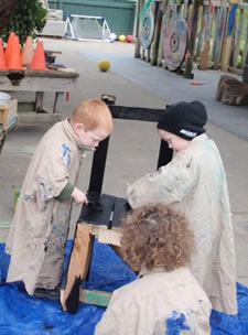 Kindergarten students working together on the chairs