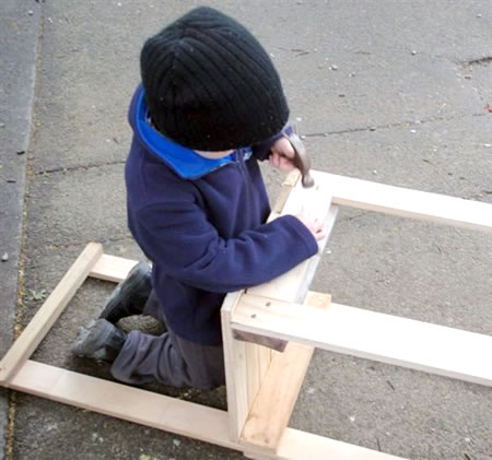 A kindergarten student working on a chair